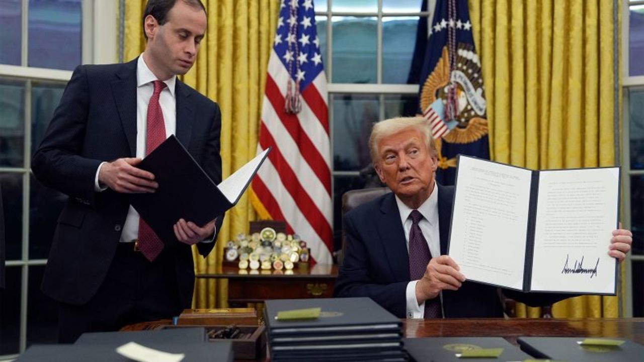 El presidente Donald Trump muestra un decreto que conmuta las sentencias de las personas condenadas por los delitos del 6 de enero en la Oficina Oval de la Casa Blanca, el lunes 20 de enero de 2025, en Washington.