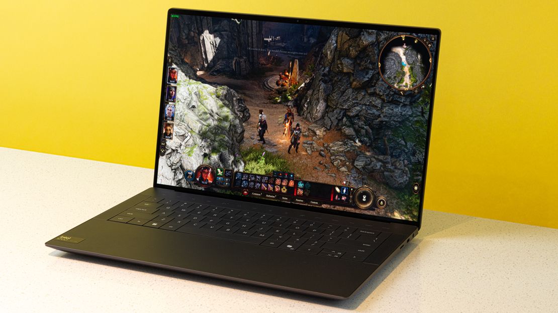 The Dell XPS 14 is open to Baldur’s Gate 3 where heroes explore a rocky area.