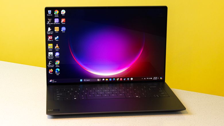 The Dell XPS 14 open to a desktop background with a purple and pink eclipse.