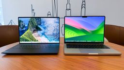 (L, R) Dell XPS 14 with a landscape wallpaper next to Apple MacBook Pro 14 with a wavy color wallpaper