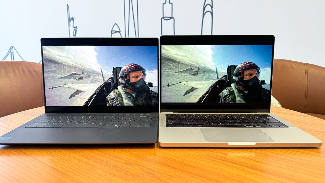 (L, R) the Dell XPS 14 and Apple MacBook Pro 14 both show a scene in Top Gun: Maverick where Tom Cruise is flying a plane, and the sky in the MacBook Pro looks slightly paler