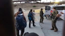 Los migrantes se dirigen a una camioneta de la Patrulla Fronteriza después de cruzar ilegalmente y esperar para solicitar asilo entre dos muros fronterizos que separan a México y Estados Unidos, el martes 21 de enero de 2025, en San Diego.