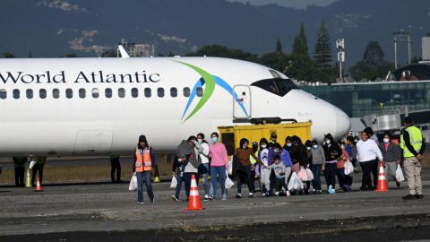 Los migrantes guatemaltecos deportados de Estados Unidos caminan por la pista de aterrizaje tras llegar a la Base Aérea de Guatemala en la Ciudad de Guatemala el 27 de diciembre de 2024, durante el último vuelo de deportados del año.