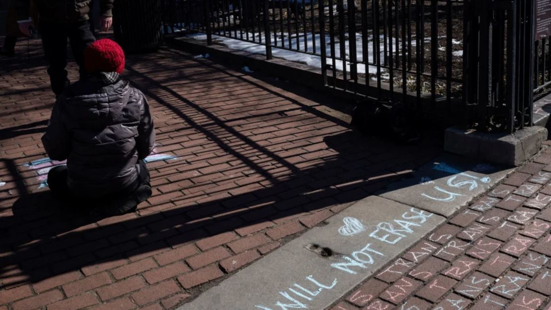 Una persona usa tizas para dibujar en el suelo durante una protesta contra una medida del Gobierno del presidente Donald Trump para restringir los derechos de las personas transgénero, en el Stonewall Inn y el Monumento Nacional Stonewall.