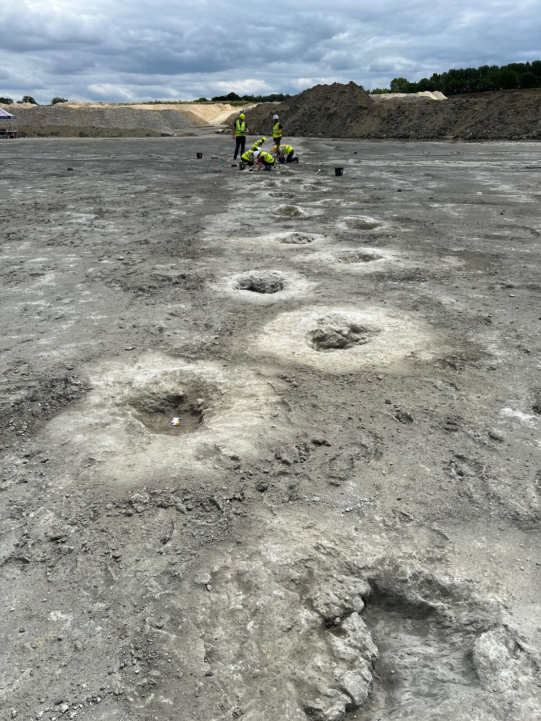 Several volunteers work to examine the footprints uncovered throughout the Oxfordshire quarry in June 2024.