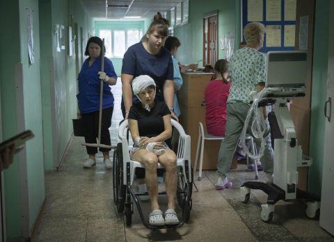 A hospital nurse pushes a wheelchair carrying a woman wounded by the Russian rocket attack at a shopping centre in Kremenchuk, Ukraine, on June 28.