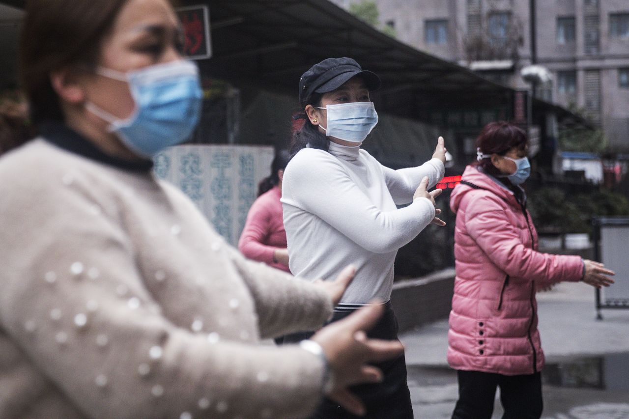 A group of women wear masks while exercising on January 27, 2020 in Wuhan, China. 