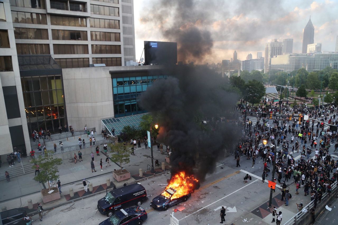 A police car burns after protesters marched to the Georgia State Capitol and returned to the area around the CNN in Atlanta, on Friday, May 29. 