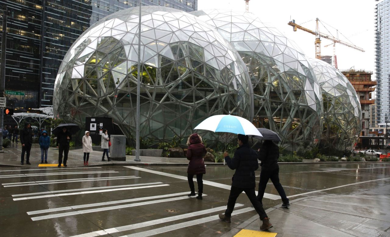 People walk past the Amazon Spheres workspace in Seattle in 2018. 