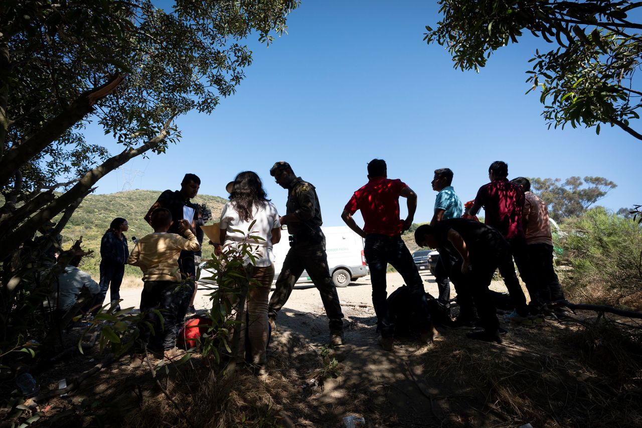 Border Patrol agents talk with migrants seeking asylum as they prepare them for transportation to be processed on June 5 near Dulzura, California. 