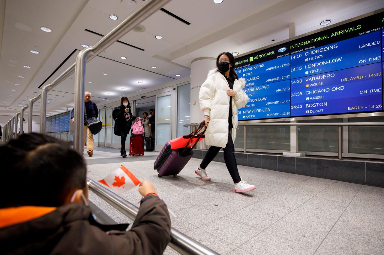 Travelers are seen wearing masks at the international arrivals area at the Toronto Pearson Airport on January 26. 