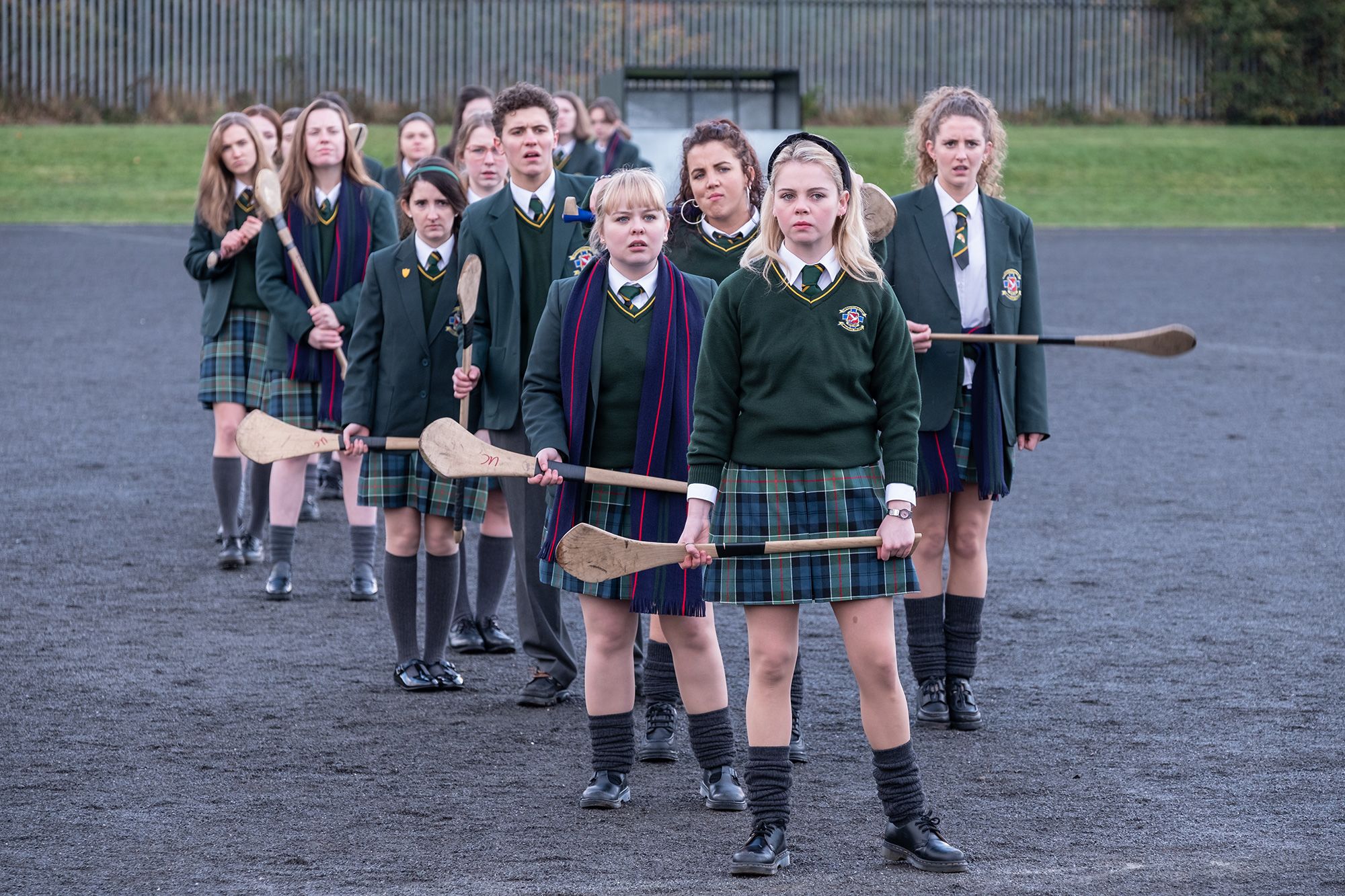 The cast of "Derry Girls" in tartan — or plaid — kilt-style skirts.