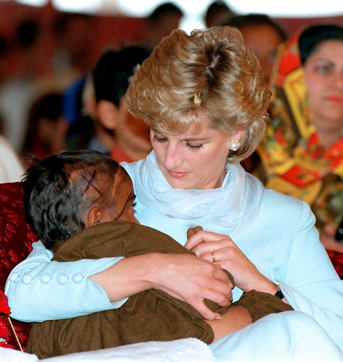 Diana comforts a child during a visit to Imran Khan's Cancer Hospital in Lahore, Pakistan in April 1996. 