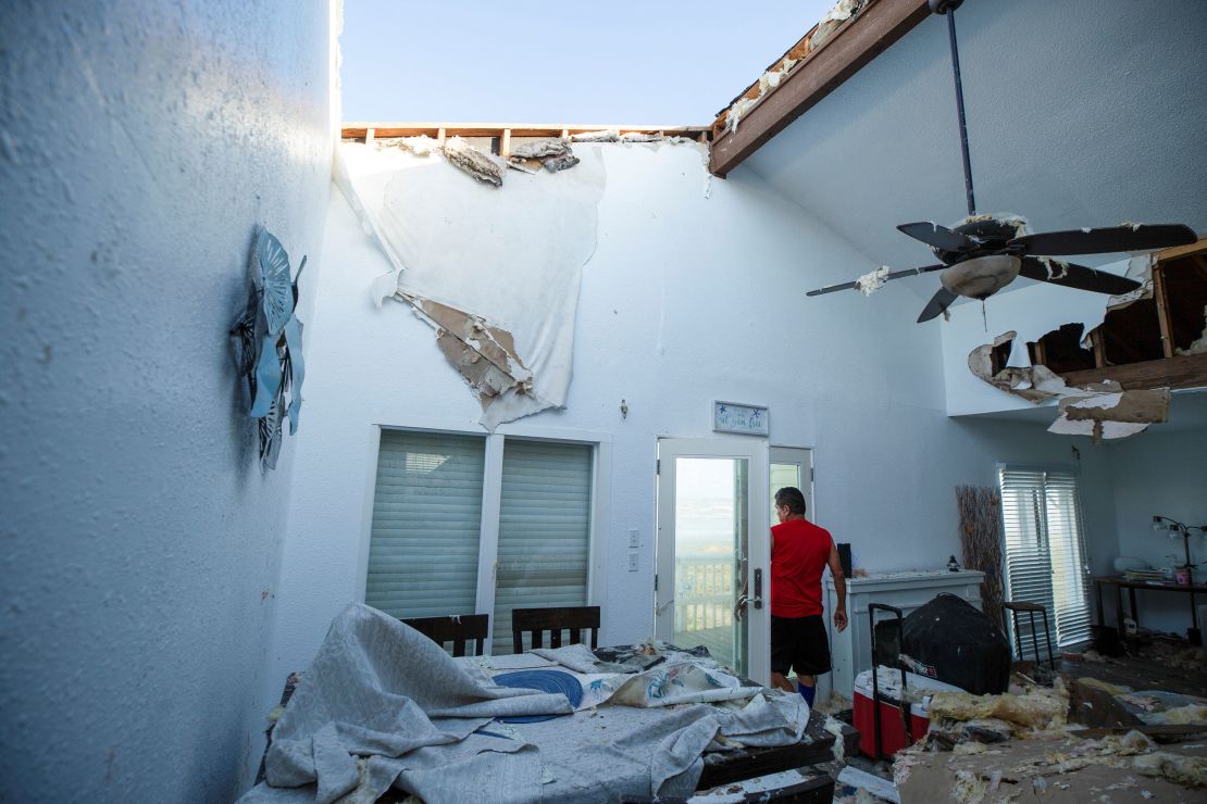 A contractor surveys a client’s home for structural damage on July 8, 2024, in Galveston, Texas, after Hurricane Beryl moved through the area.