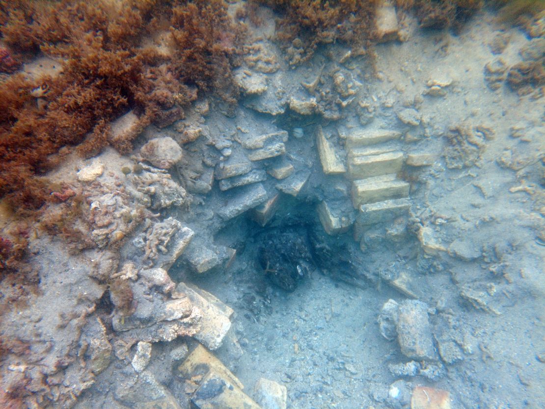 Seen here is an excavated hole with visible bricks and wood from the shipwreck.