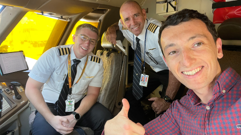 Travel products editor Kyle Olsen with United pilots in the cockpit of a Boeing 777-300ER