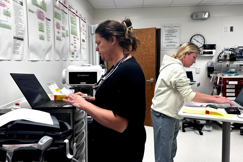 Physician assistant Carla Dowdy, left, takes notes while treating a patient in the Ekalaka hospital as nurse Willow Meyer works nearby.