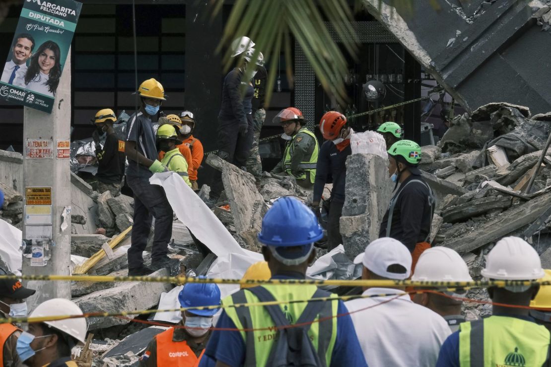 Los rescatistas usan sábanas para recuperar cuerpos de entre los escombros.