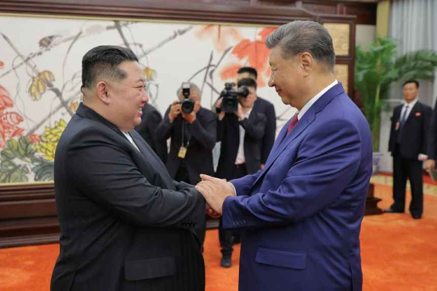In this photo released by North Korean state media Rodong Sinmun, North Korean leader Kim Jong Un, left, shakes hands with Chinese President Xi Jinping in Beijing on Thursday.