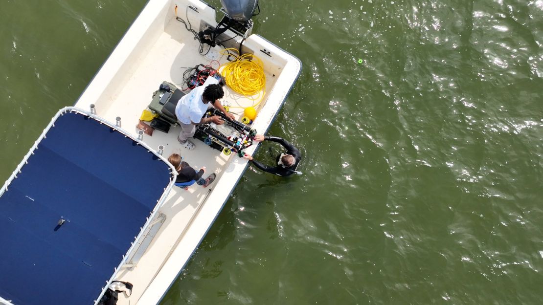 Chris Oakes, CEO of ReefGen, is seen here in the southern end of the Outer Banks, North Carolina, preparing to place Grasshopper, a seagrass planting robot, on the ocean floor to plant eel grass seeds.