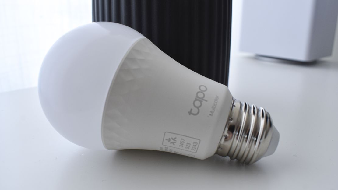 A Tapo L535E bulb on a white table.