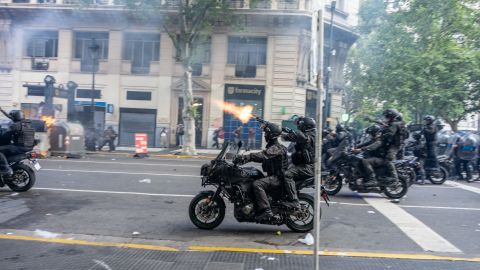 Un policía federal dispara una bala de goma contra los manifestantes.