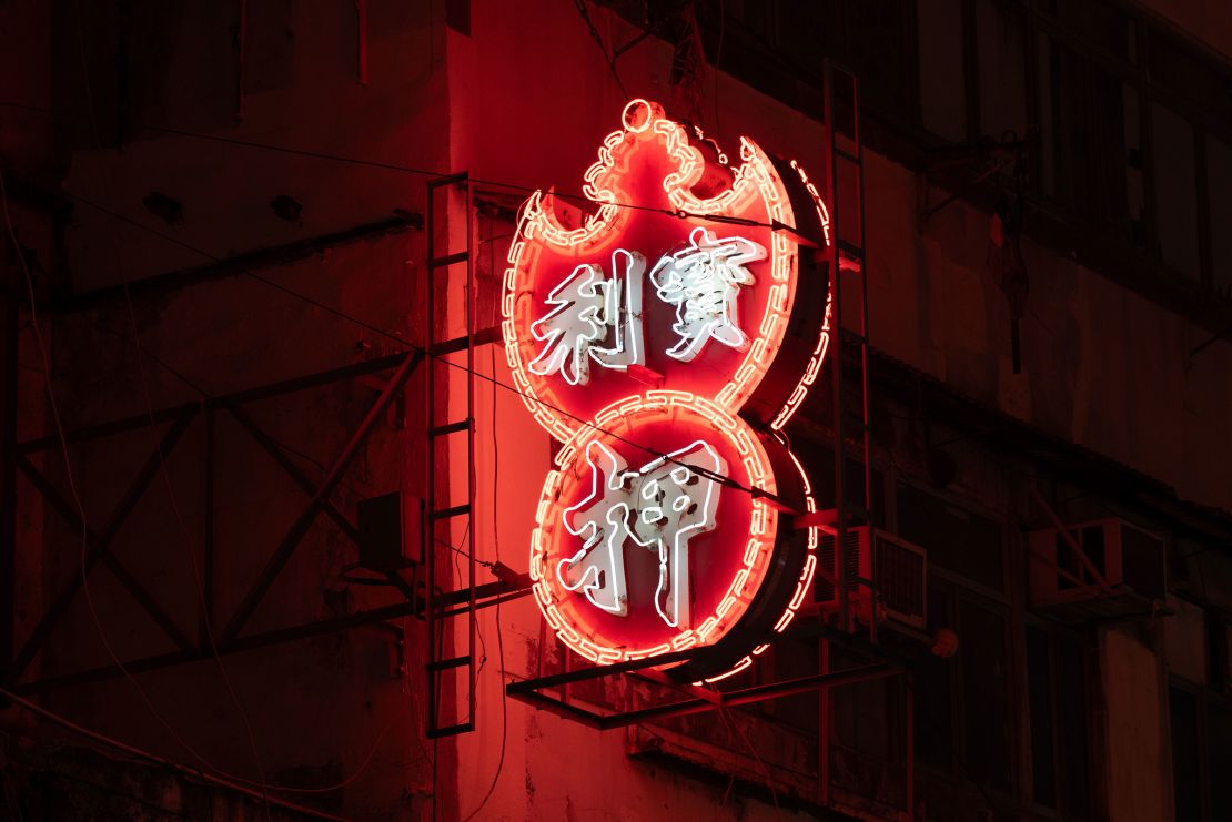 A neon pawn shop sign lights up the roadside in Kowloon area of Hong Kong.