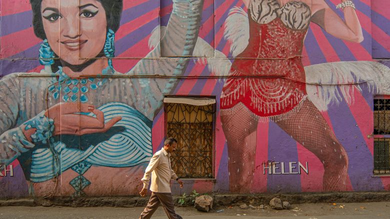 A man walks past a mural portraying Bollywood Indian actresses Asha Parekh and Helen, in Mumbai, India, on April 17, 2024.