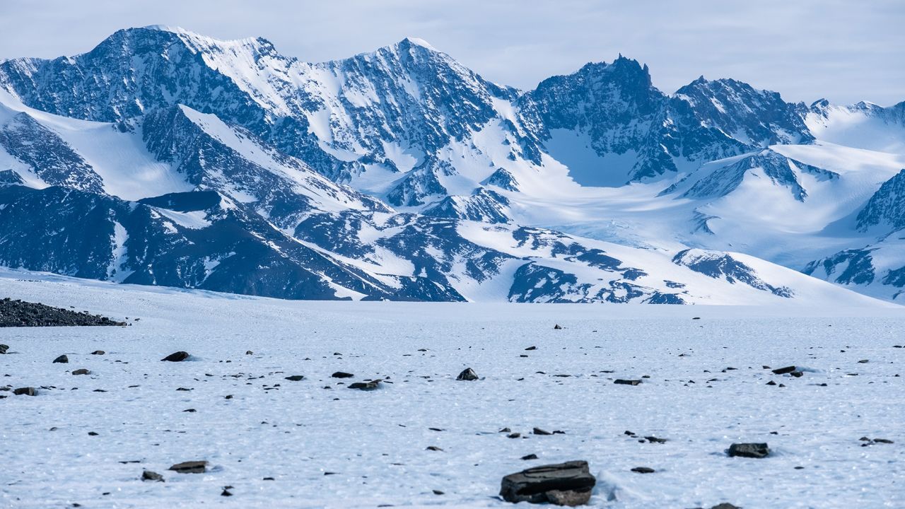 Terrestrial stones on a blue ice area in mountainous terrain. Photo taken during the 2022 fieldwork mission of the Instituto AntÃ¡rtico Chileno (INACH) to Union Glacier, Ellsworth Mountains, Antarctica. 