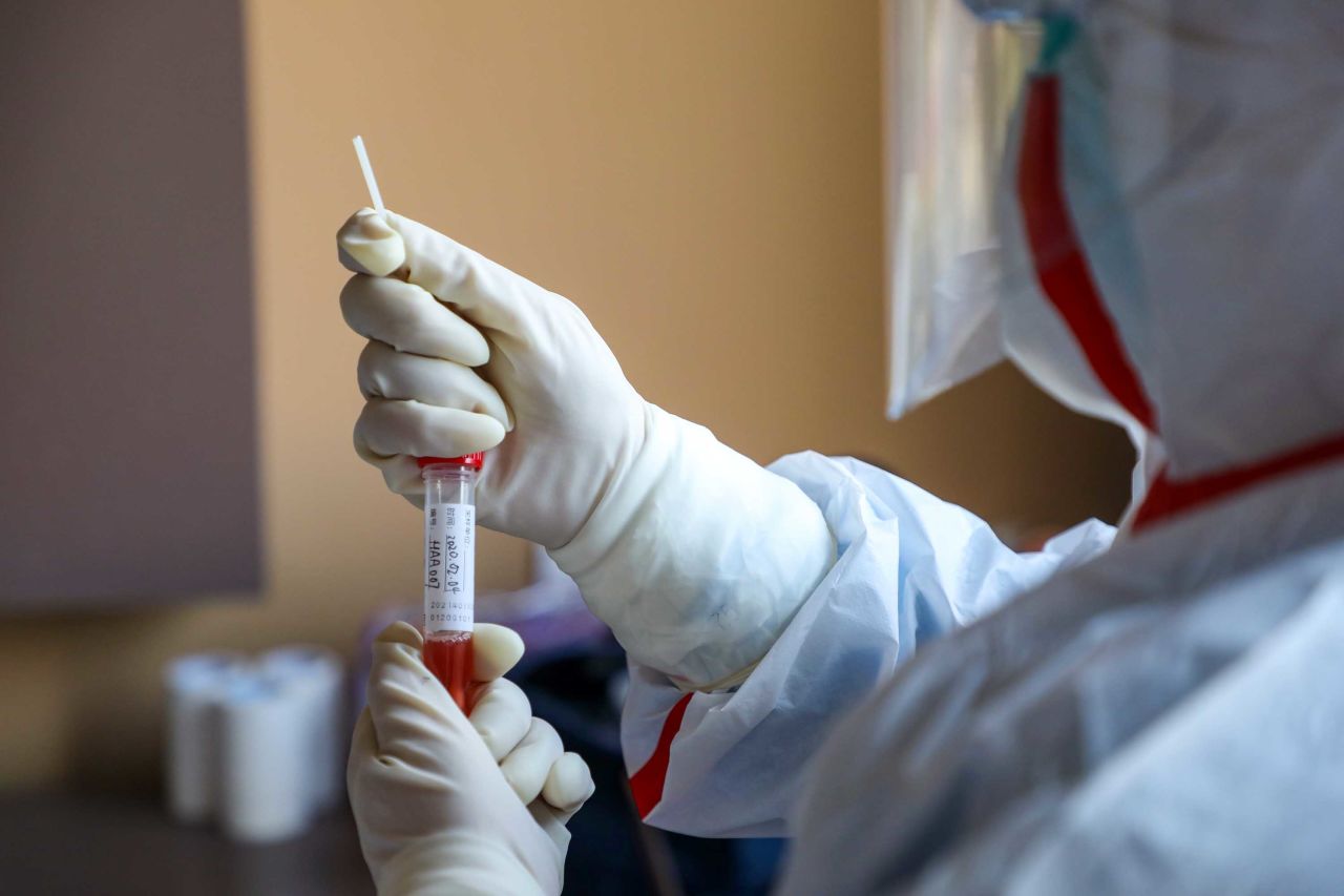 A medical worker collects biomaterial for testing from a suspected coronavirus patient in Wuhan on Tuesday.