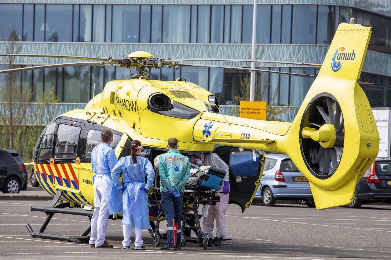 Medical workers are seen alongside a trauma helicopter as they transport a coronavirus patient on April 12 in Den Haag, Netherlands.