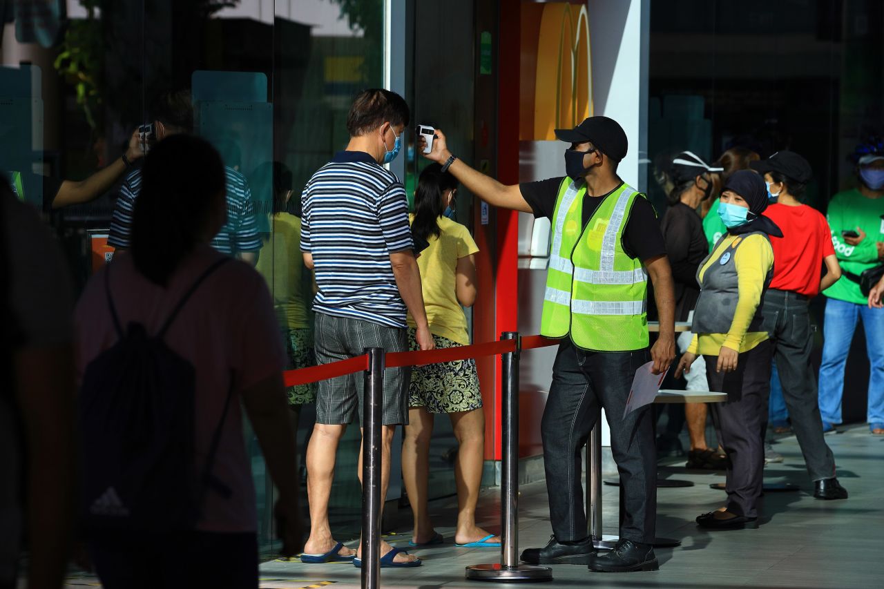 A man wearing a protective mask has his temperature taken before entering a McDonald's restaurant in Singapore, on May 12.?