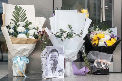 A photo of the late ophthalmologist Li Wenliang is seen beside flower tributes at the Wuhan Central Hospital on Friday.