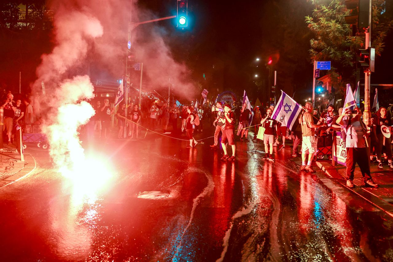 Protestors light flares near the residence of the Israeli prime minister during an anti-government rally calling for early elections, in Jerusalem on Monday, June 17.