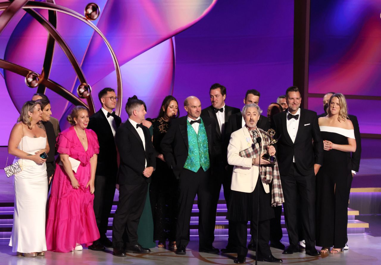 "Traitors" host Alan Cumming, front, accepts the award for best reality or competition series. 