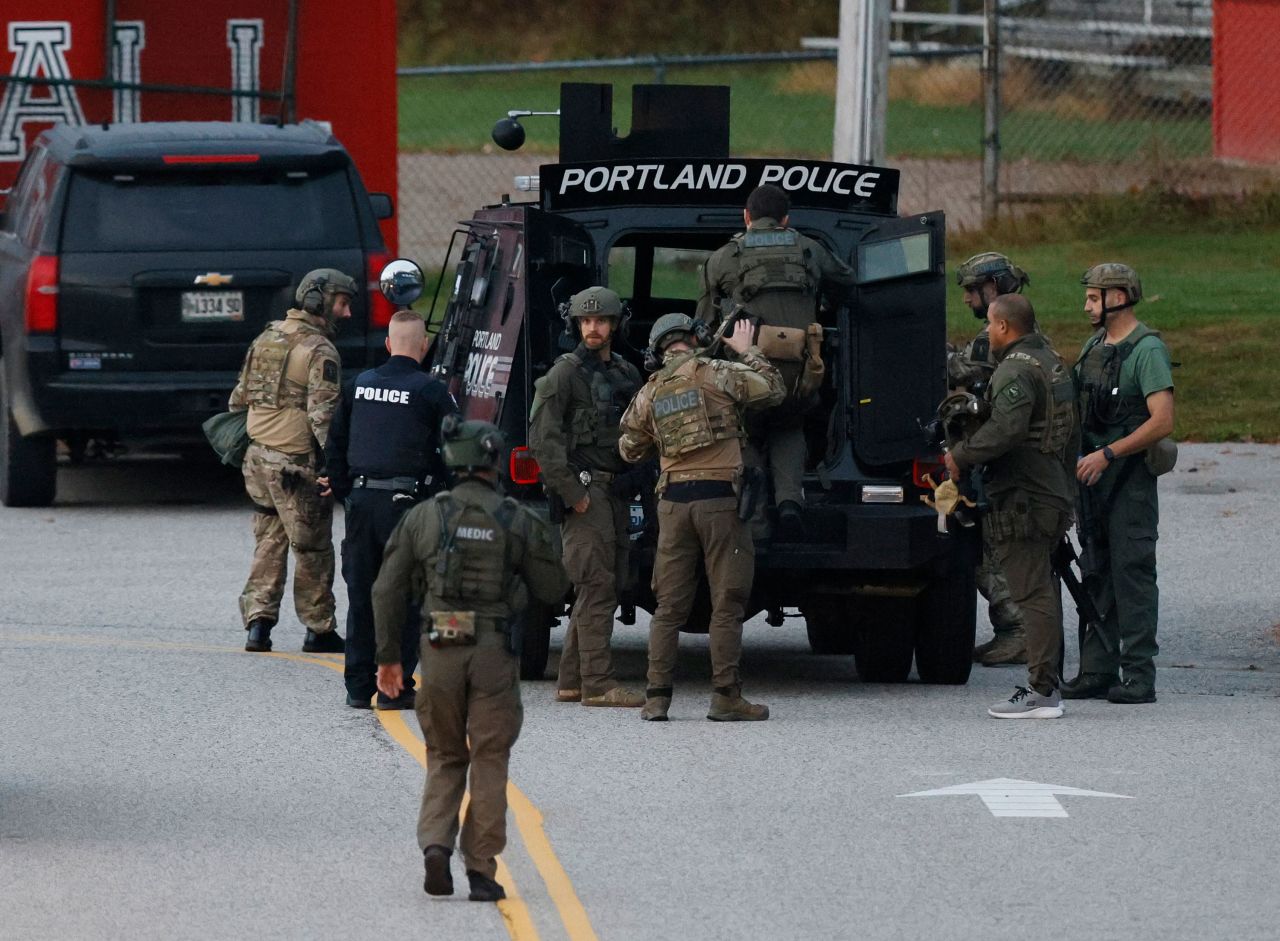 Law enforcement officials load into a tactical vehicle at Lisbon High School on Thursday.?