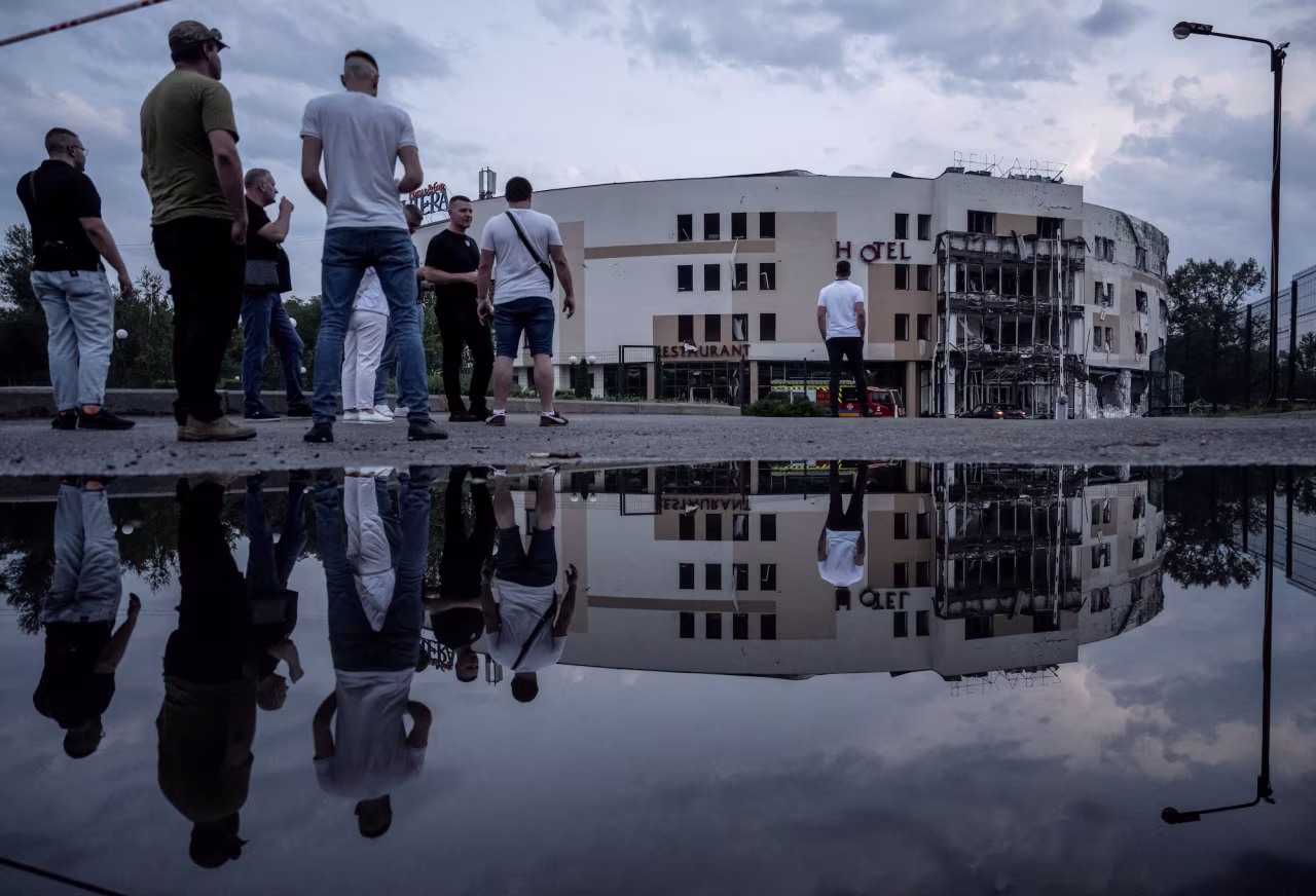 People stand near the site of a Russian missile strike in Zaporizhzhia on Thursday, August 10, 2023.