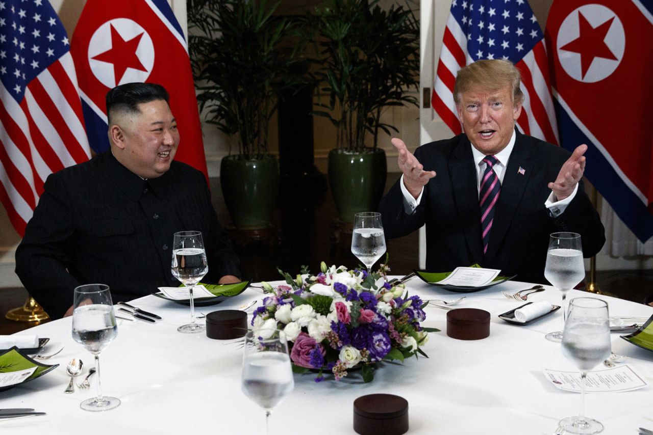 Trump jokes with photographers as Kim looks on at the start of a dinner on Wednesday. 