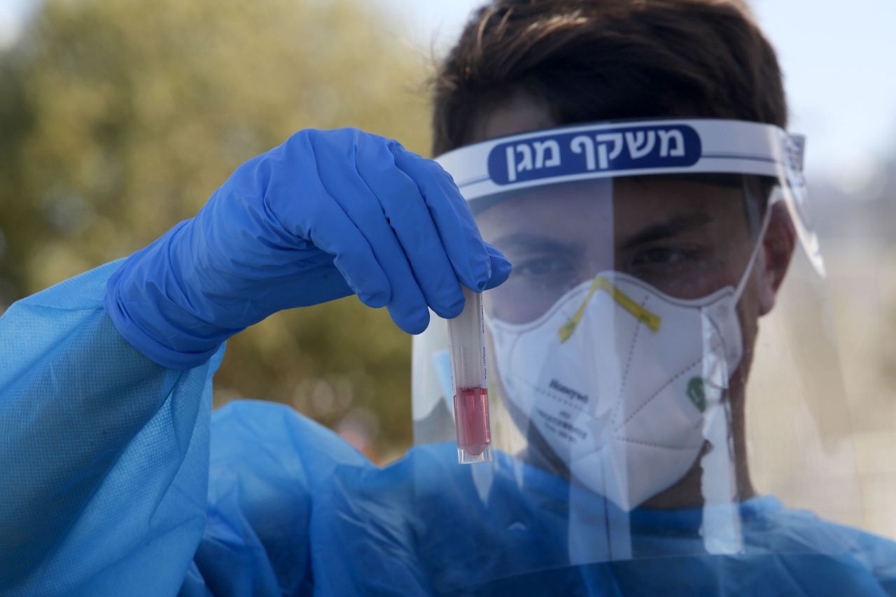 A medical worker holds a Covid-19 test sample in Petah Tikva, Israel, in October 2020.