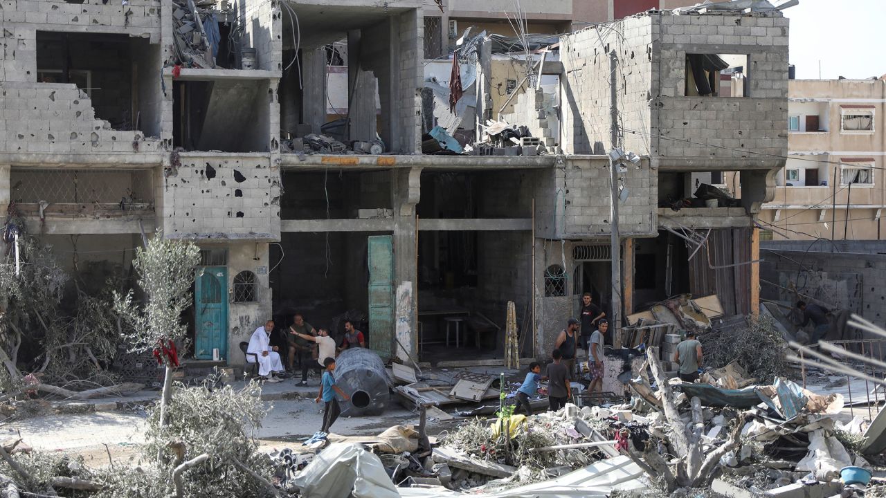 People walk among debris in the aftermath of Israeli strikes in the area where Israeli hostages were rescued in Nuseirat refugee camp, Gaza, on June 9.