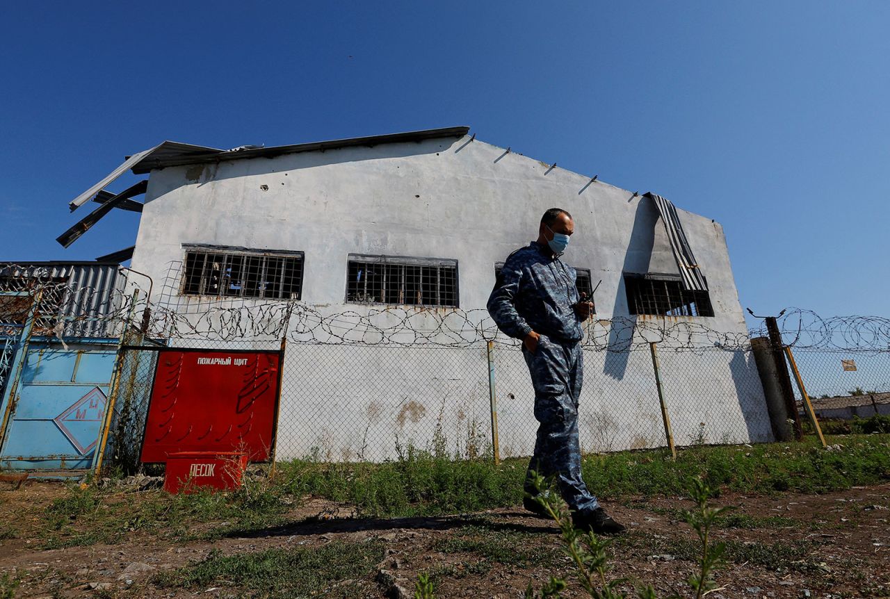 A security guard stands in front of the prison building, which was damaged by shelling in July, in Olenivka on August 10, 2022.