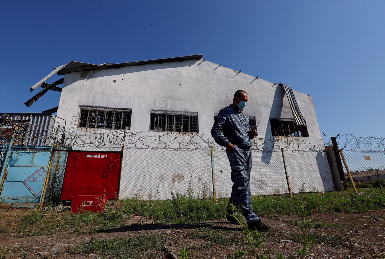 A security guard stands in front of the prison building, which was damaged by shelling in July, in Olenivka on August 10, 2022.