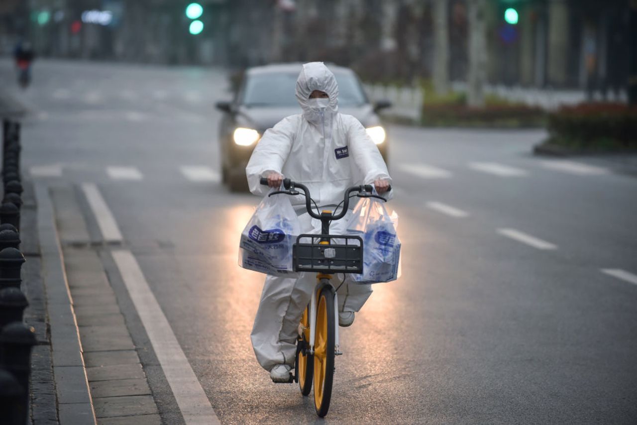 A resident wears a protective suit as they ride a bicycle in Wuhan in China's central Hubei province on February 27, 2020.  