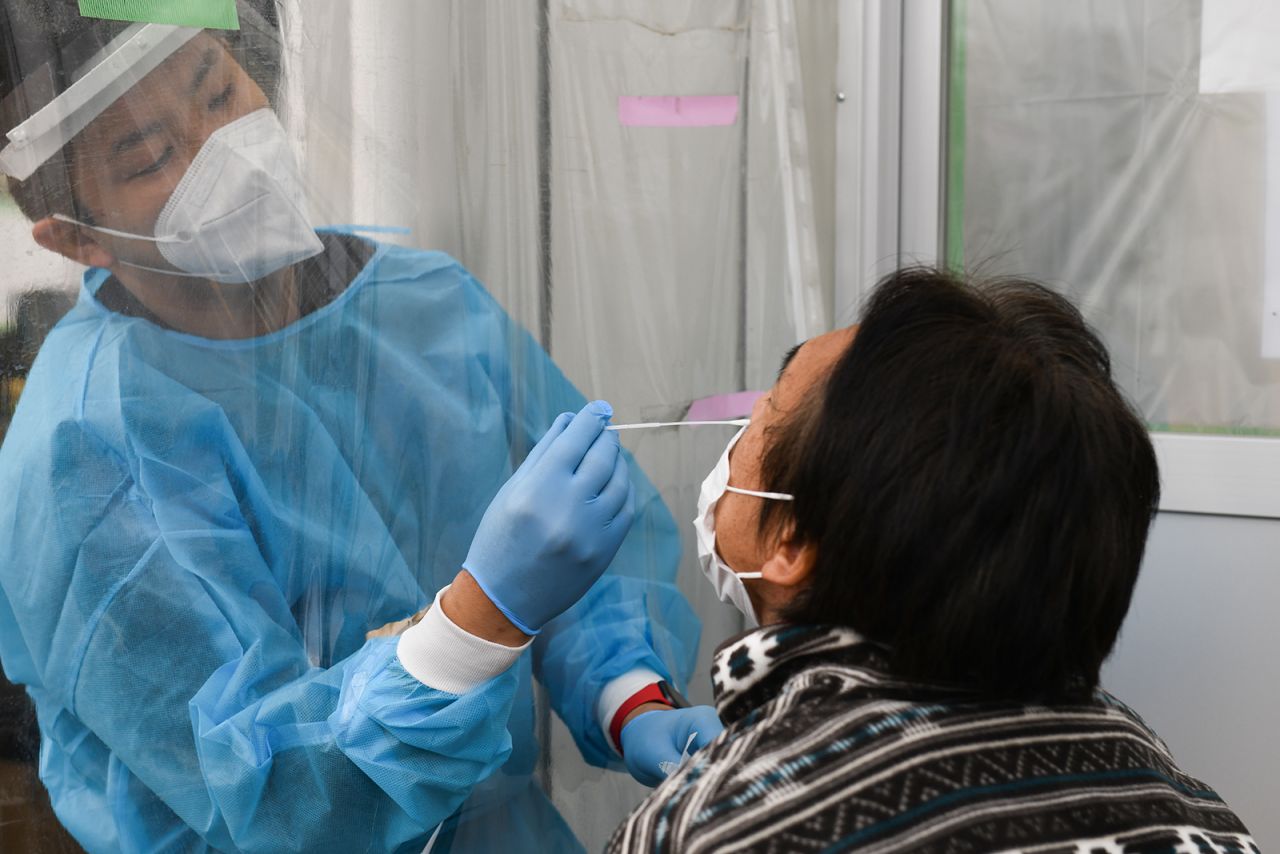 A healthcare worker wearing personal protective equipment (PPE) collects a swab sample at the coronavirus testing center set up at Fujimino Emergency Hospital in Miyoshi-machi, Saitama Prefecture, Japan, on December 9.