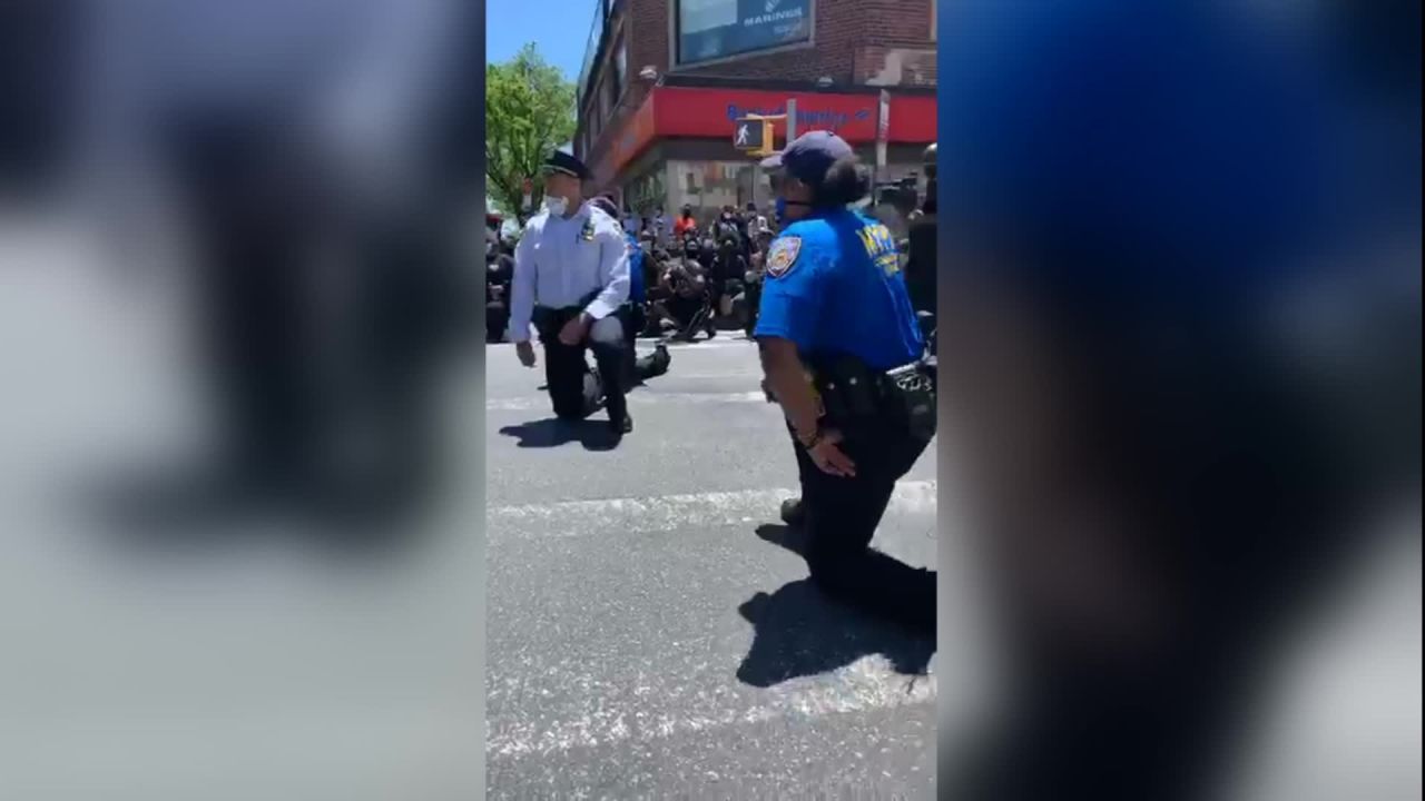 NYPD officers are seen kneeling with protesters on May 31.