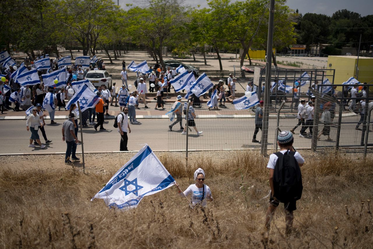 Israelis march with national flags in Sderot, Israel, on Tuesday.