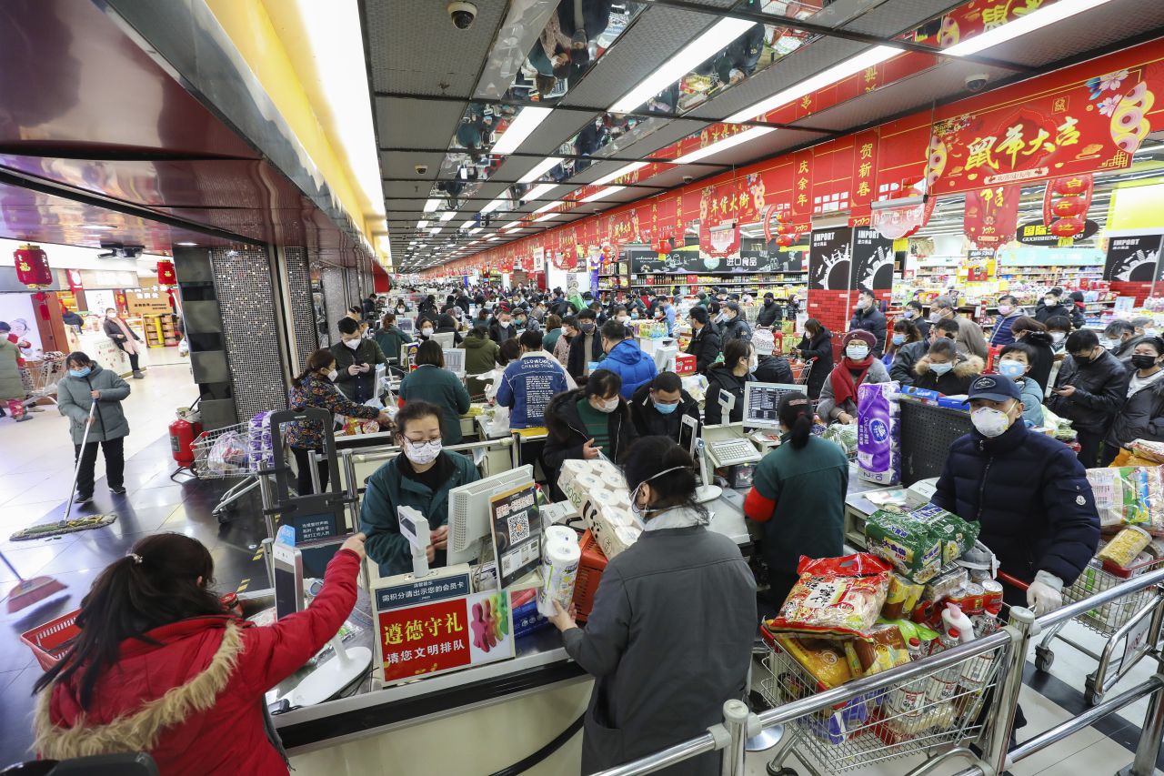 Shoppers wearing face masks pay for their groceries at a supermarket in Wuhan on Saturday.