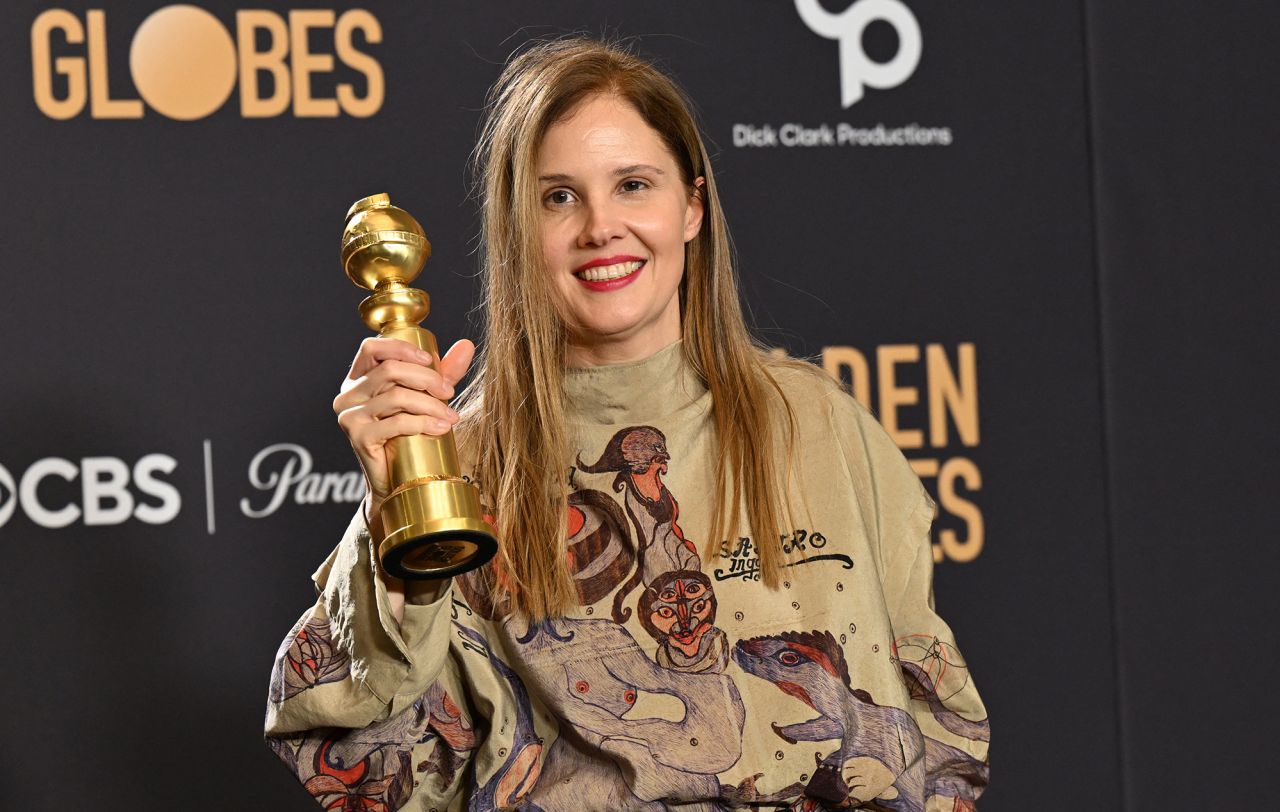 Justine Triet poses with a Golden Globe award.