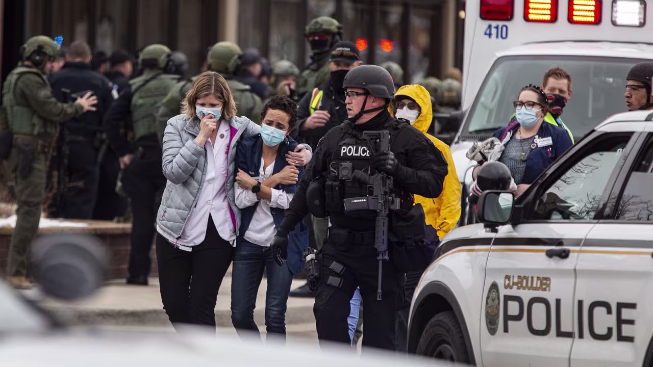 Healthcare workers walk out of a King Sooper's Grocery store after a gunman opened fire on March 22, in Boulder, Colorado.