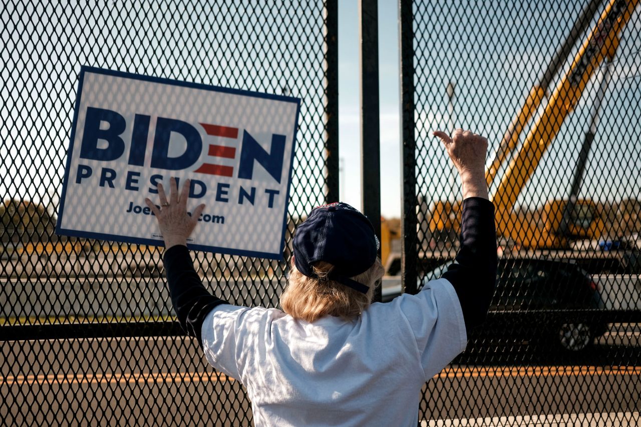 A Joe Biden supporter waits outside the Chase Center in Wilmington, Delaware, on November 7, 2020.??